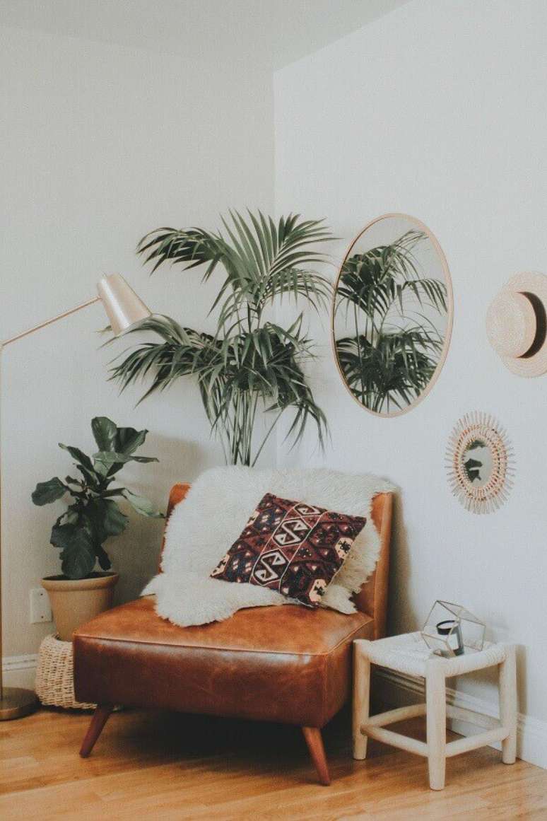 30. Sala decorada com poltrona de couro marrom e vasos de plantas – Foto: Pinterest