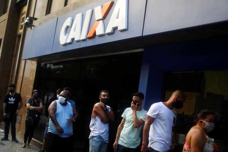 Pessoas formam fila em torno de agência da Caixa para receberem o auxílio emergencial concedido pelo governo. 29/04/2020. REUTERS/Pilar Olivares. 

