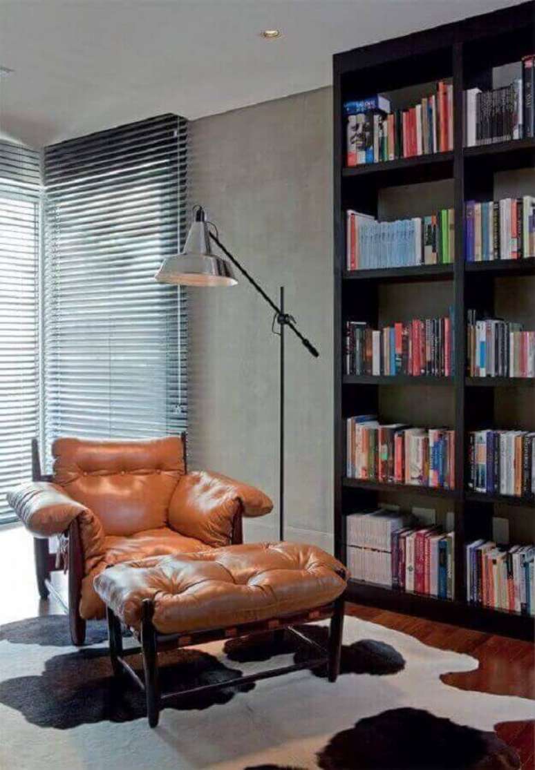 34. Decora&ccedil;&atilde;o de cantinho de leitura com confort&aacute;vel poltrona marrom e estante de livros preta &ndash; Foto: Pinterest