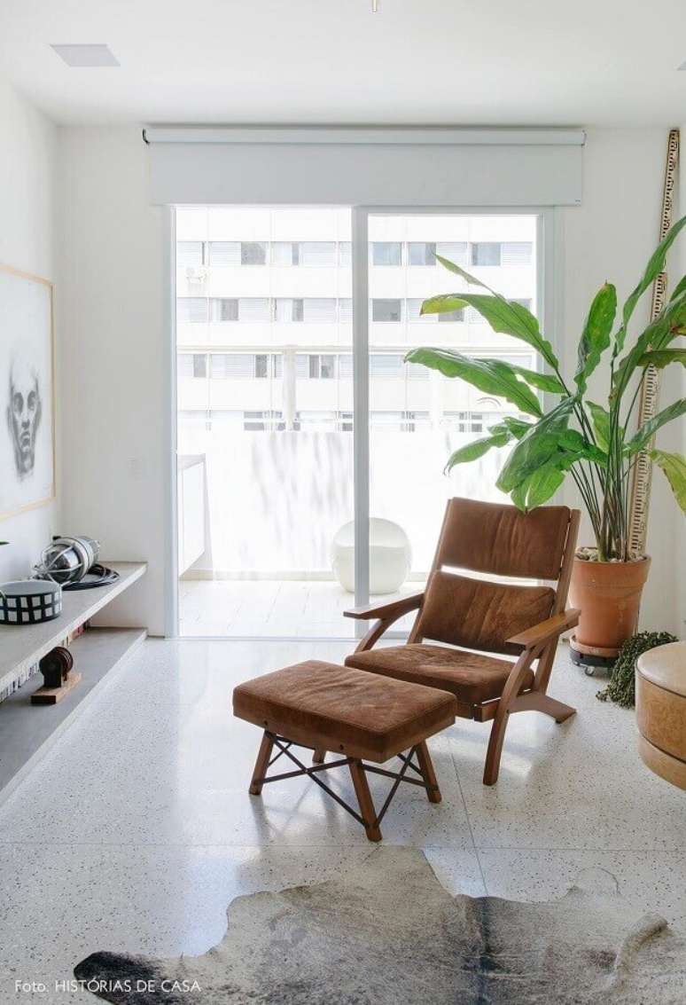 31. Decora&ccedil;&atilde;o de sala toda branca com poltrona marrom com puff &ndash; Foto: Hist&oacute;rias de Casa