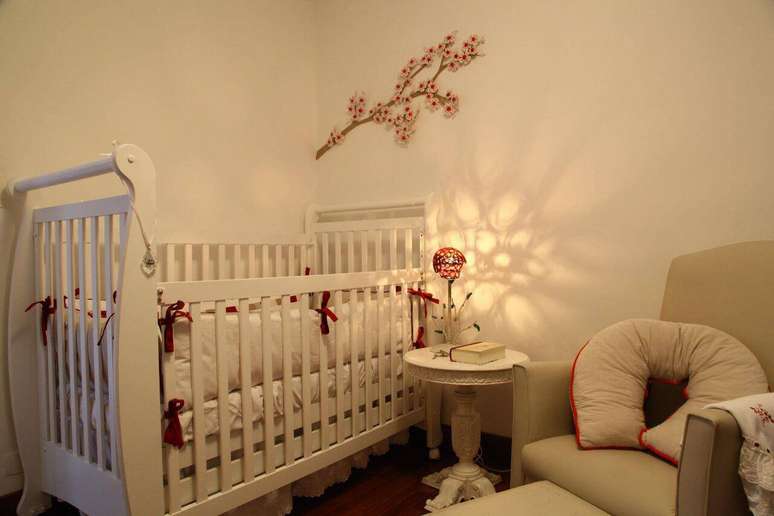 28. A mesinha auxiliar ao lado da poltrona de amamentar facilita a rotina. Projeto por Anna Paula Moraes.