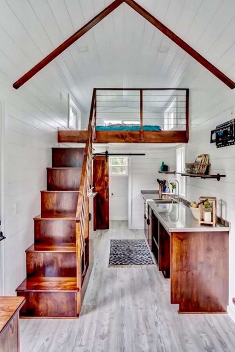 49. A escada estreita de madeira leva at&eacute; a cama mezanino casal. Fonte: Deguile M&oacute;veis