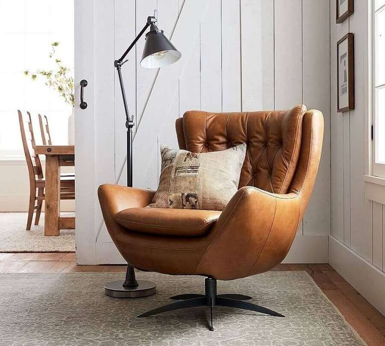 36. Sala decorada com lumin&aacute;ria de piso e poltrona marrom girat&oacute;ria &ndash; Foto: Pottery Barn