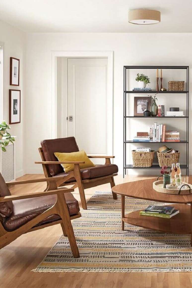 25. Poltrona marrom de madeira para sala decorada com estante estilo industrial – Foto: Room & Board