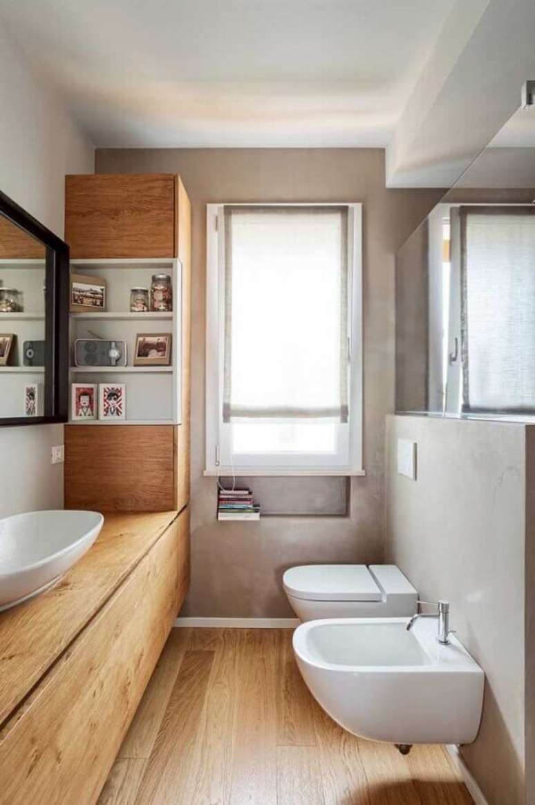 15. Banheiro social decorado com cimento queimado e bancada de madeira – Foto: Andreas Móveis