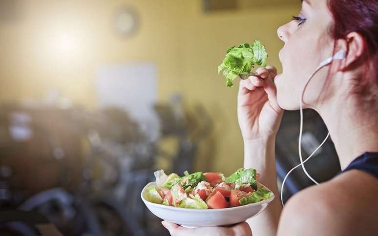 Mulher comendo salada na academia