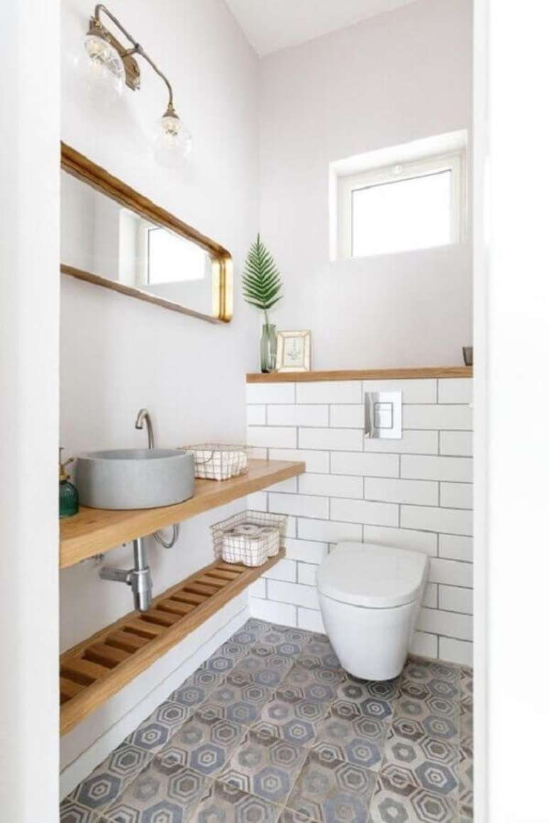 5. Bancada de madeira para banheiro social simples decorado com piso antigo – Foto: Pinterest