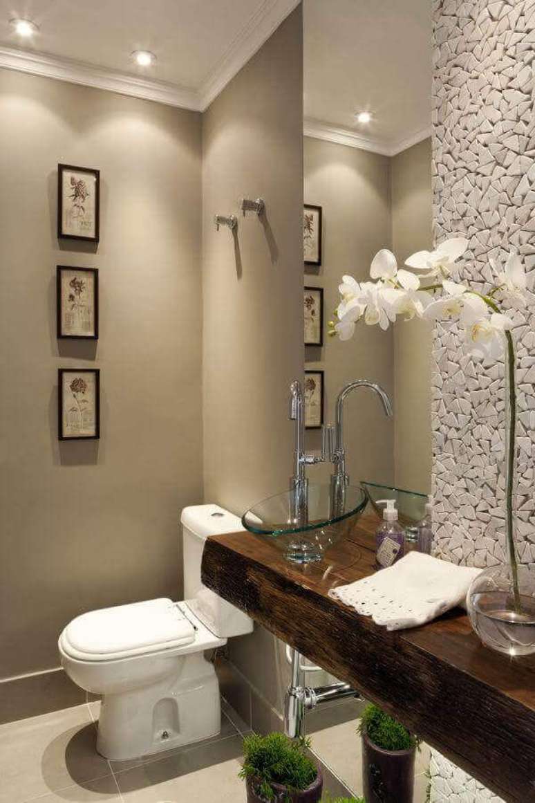 14. Bancada de madeira com cuba de vidro para decora&ccedil;&atilde;o de banheiro social com revestimento de pedra para parede &ndash; Foto: Pinterest