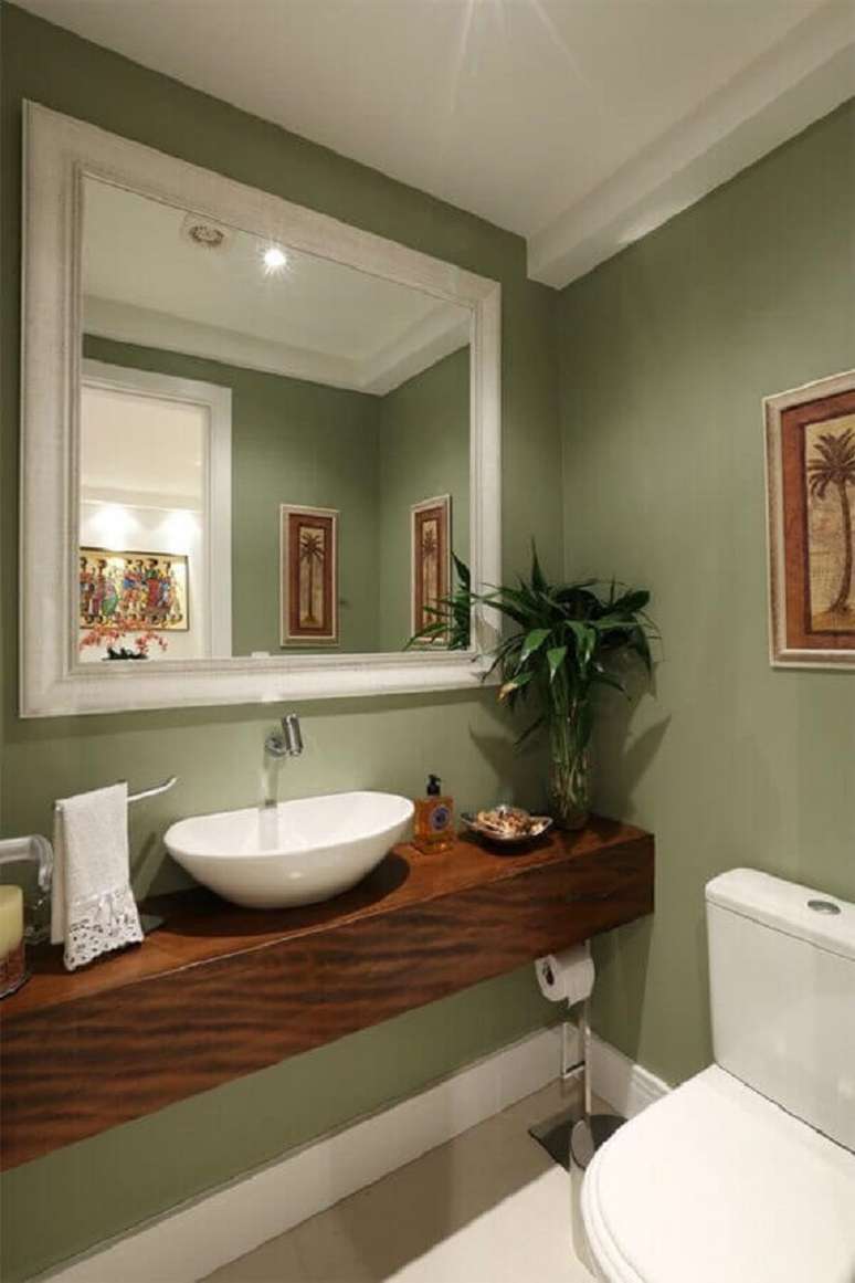 24. Parede verde oliva para banheiro decorado com bancada de madeira – Foto: Casa de Valentina