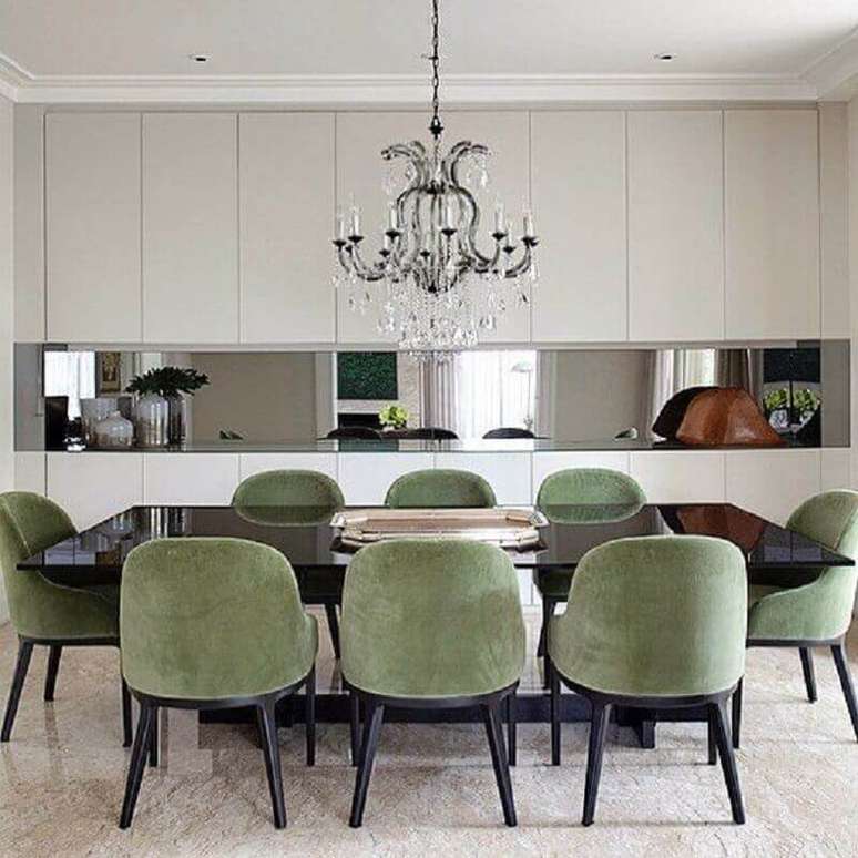 14. Sala de jantar sofisticada decorada com cadeira estofada com tecido verde oliva e lustre de cristal – Foto: Paula Magnani