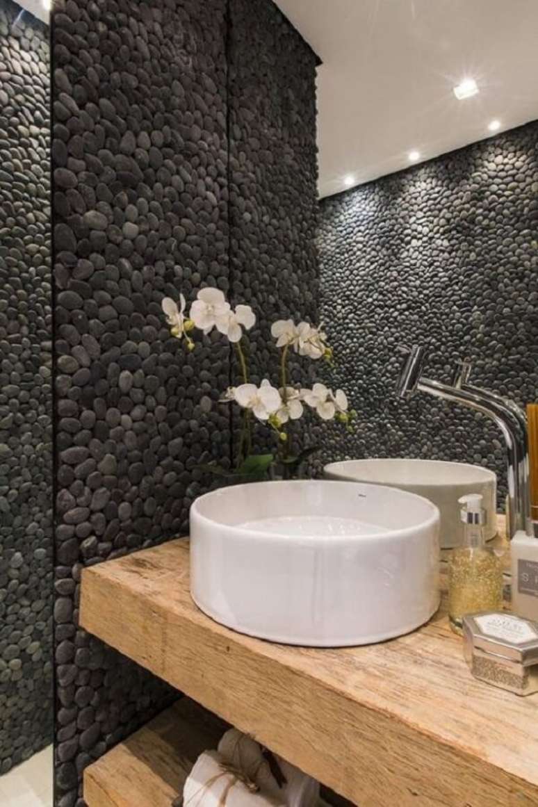 28. Revestimento de pedra feito com seixos pretos valoriza a decoração desse banheiro. Fonte: Pinterest
