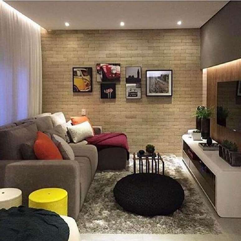 46. Puff preto redondo para decoração de sala de TV com parede tijolinho – Foto: Pinterest