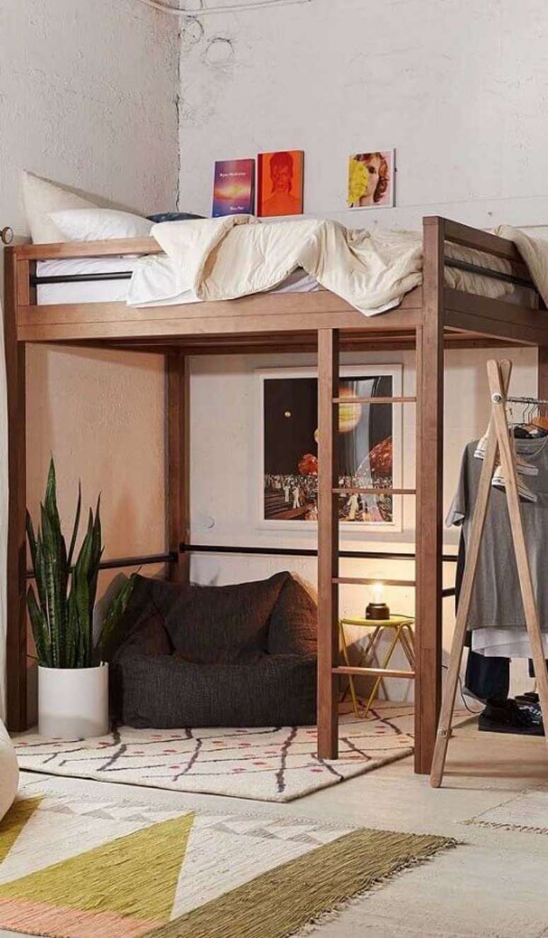 9. Decoração de quarto simples com puff fofão preto embaixo de cama suspensa – Foto: Jeito de Casa
