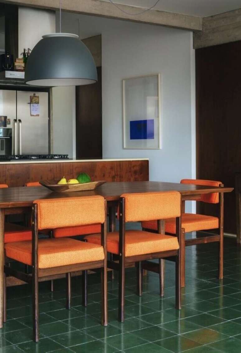 24. Cozinha com ilha decorada com mesa de madeira e cadeiras acolchoadas – Foto: História de Casa