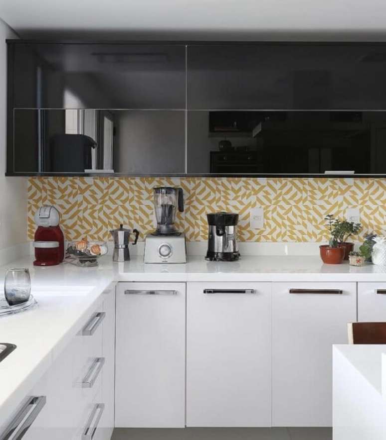 19. O armário basculante de cozinha preto se harmoniza com o revestimento de parede amarelo. Fonte: Pinterest