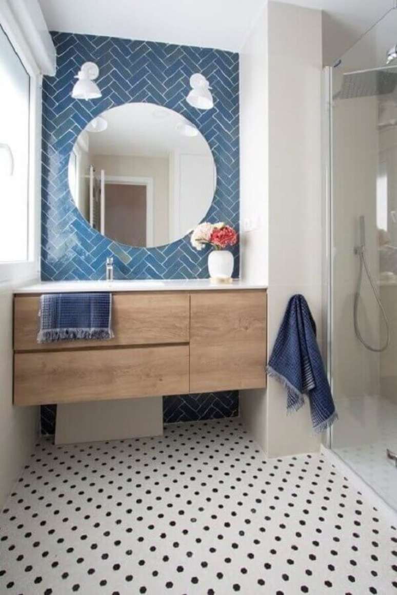 60. Gabinete de madeira suspenso para decoração de banheiro azul e branco com piso preto e branco – Foto: Pinterest