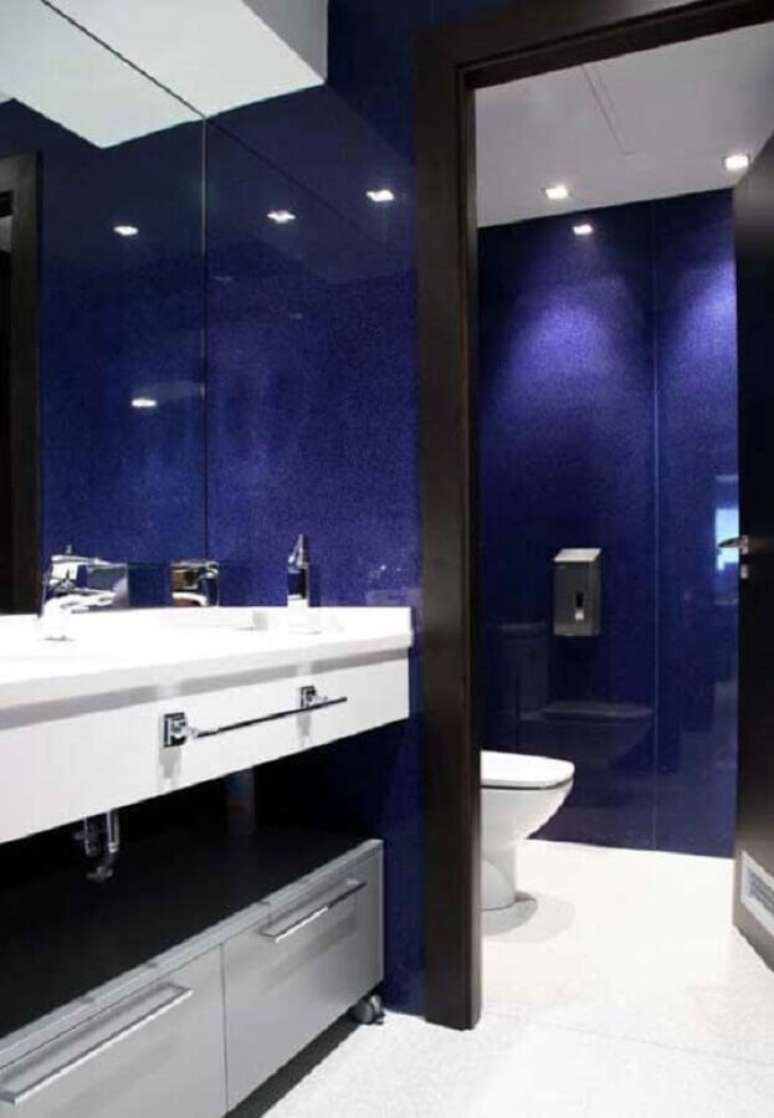 14. Gabinete branco planejado para decoração de banheiro azul marinho com detalhes em preto – Foto: Futurist Architecture