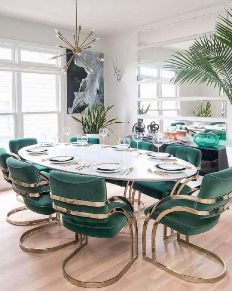 47. Decoração de sala de jantar com cadeira acolchoada moderna e mesa de jantar oval – Foto: Apartment Therapy
