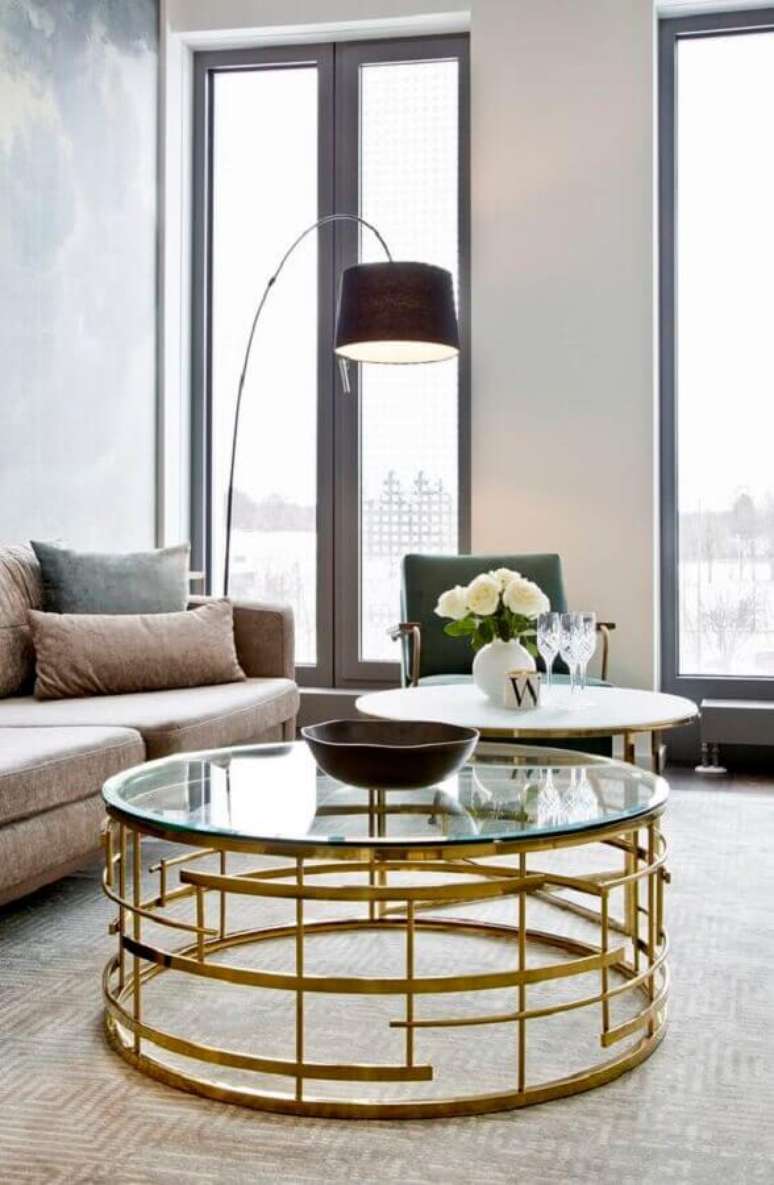 49. Sala de estar decorada com mesa de centro redonda de vidro com estrutura dourada – Foto: Homedit