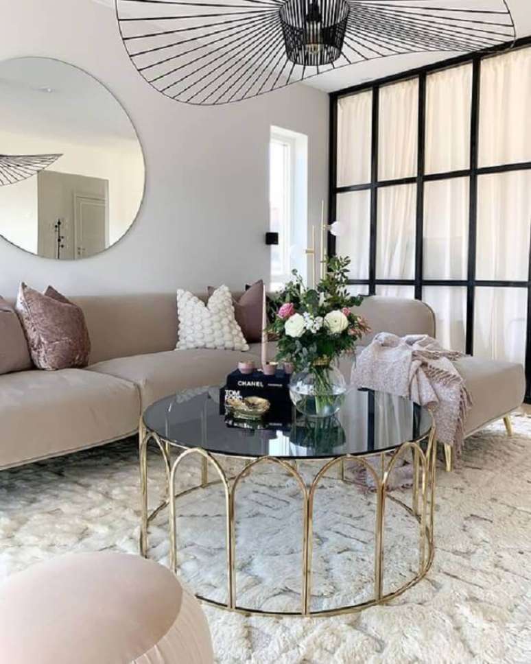 30. Modelo de mesa de centro redonda espelhada com estrutura dourada para decorar sala com sofá com chaise – Foto: Curated Interior