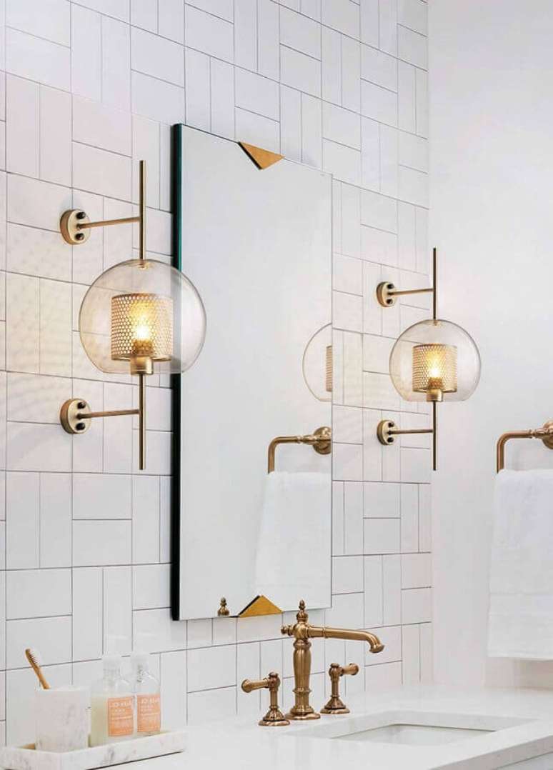 43. Decora&ccedil;&atilde;o clean com lumin&aacute;ria decorativa de parede para banheiro branco com detalhes em cobre &ndash; Foto: Tudo & Co