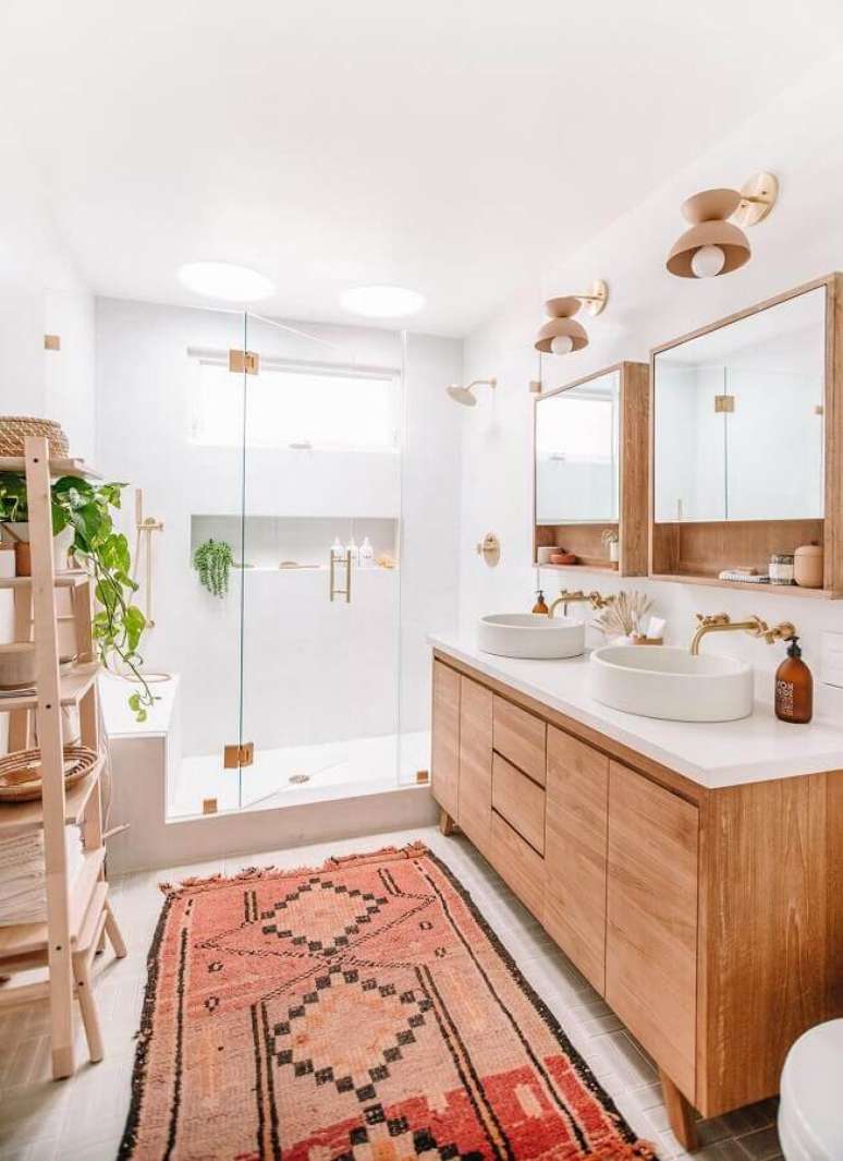 40. Decoração clean com gabinete de madeira e luminária de parede para banheiro – Foto: Apartment Therapy