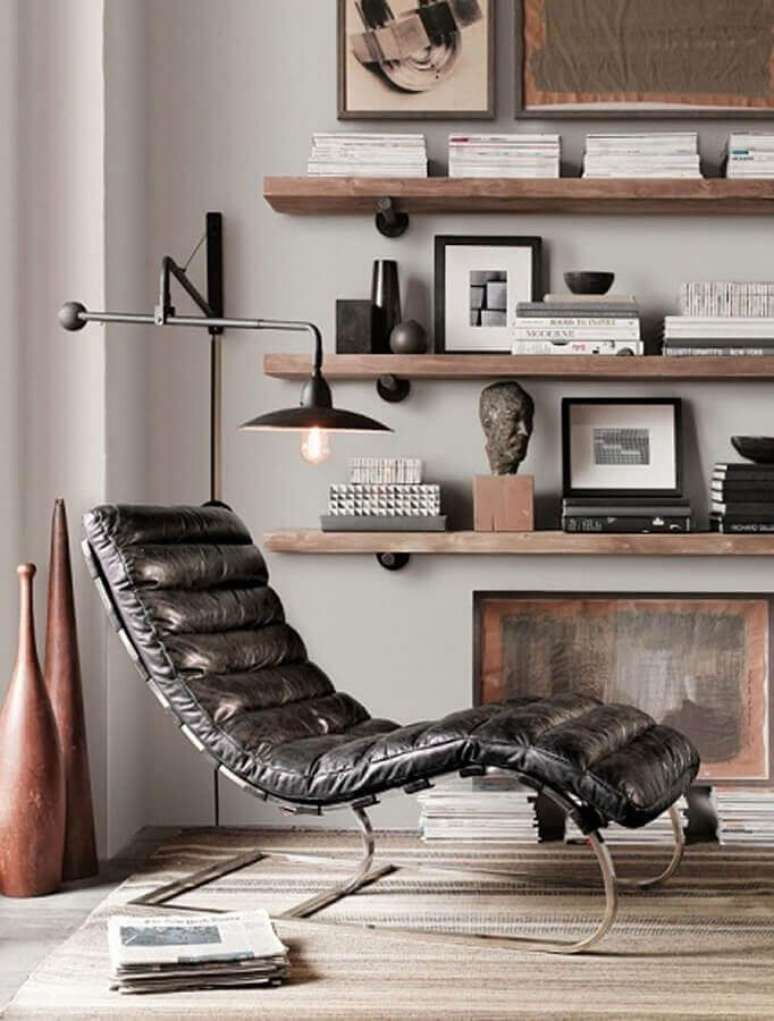 45. Luminária de parede para leitura em sala decorada com confortável poltrona preta de couro – Foto: Archzine