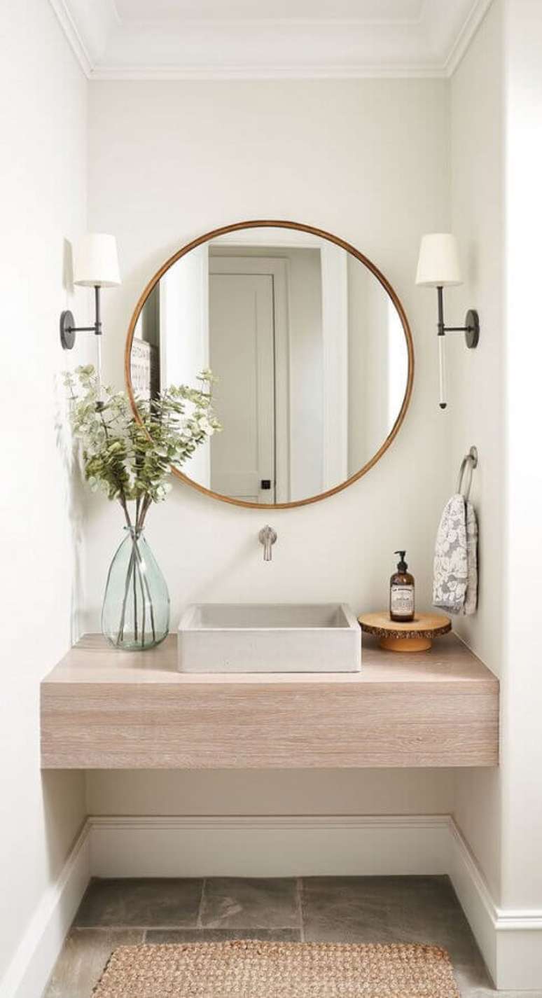 44. Decora&ccedil;&atilde;o com bancada de madeira e lumin&aacute;ria de parede para banheiro &ndash; Foto: Home Bunch