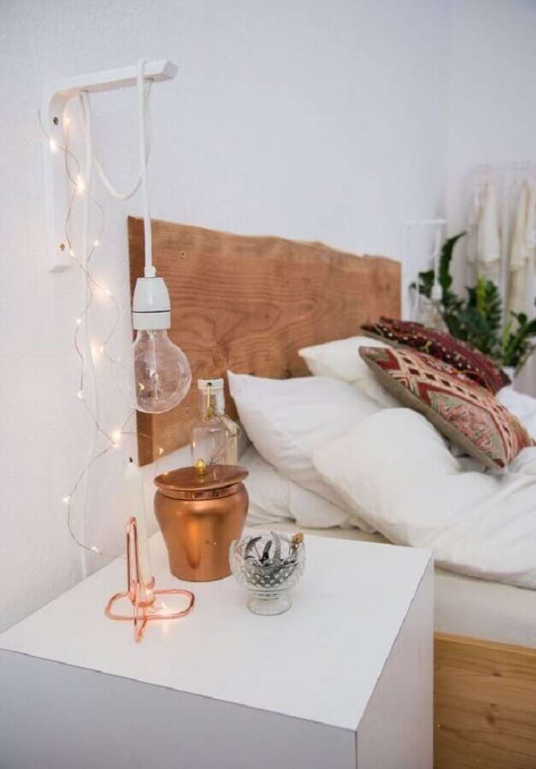 55. Quarto branco decorado com cabeceira de madeira r&uacute;stica e lumin&aacute;ria de parede simples &ndash; Foto: Jeito de Casa