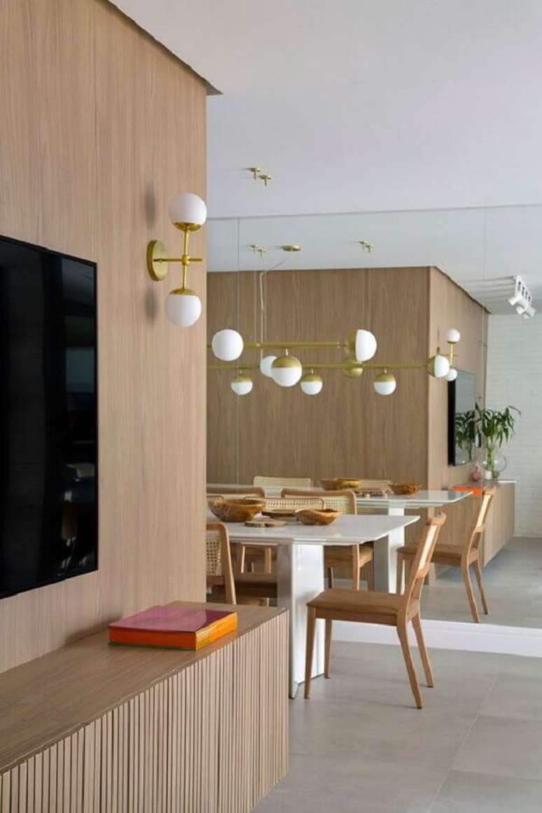 54. Lumin&aacute;ria de parede para sala de TV integrada com sala de jantar moderna &ndash; Foto: Casa de Valentina