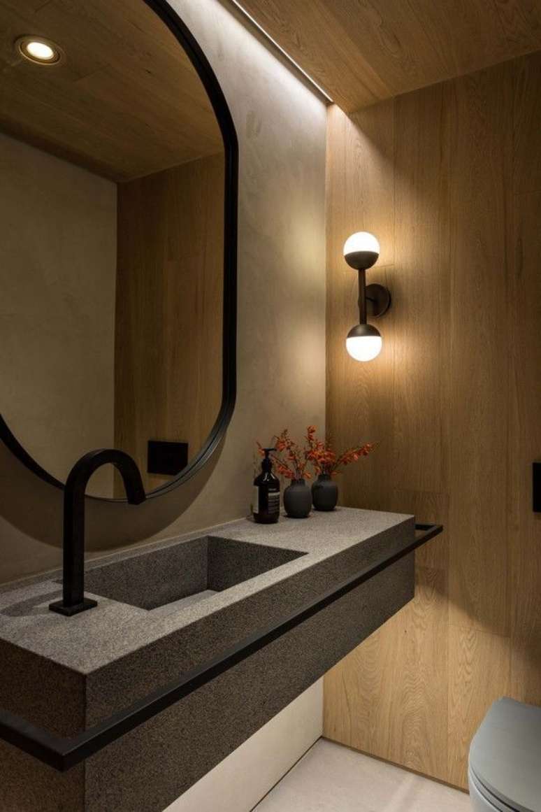 2. Banheiro moderno decorado com luminária de parede e parede amadeirada – Foto: Pinterest