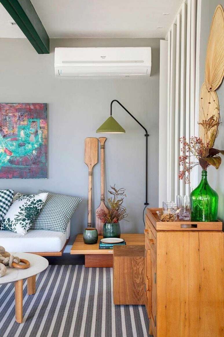 52. Luminária de parede para sala cinza moderna decorada com tapete listrado – Foto: Casa de Valentina