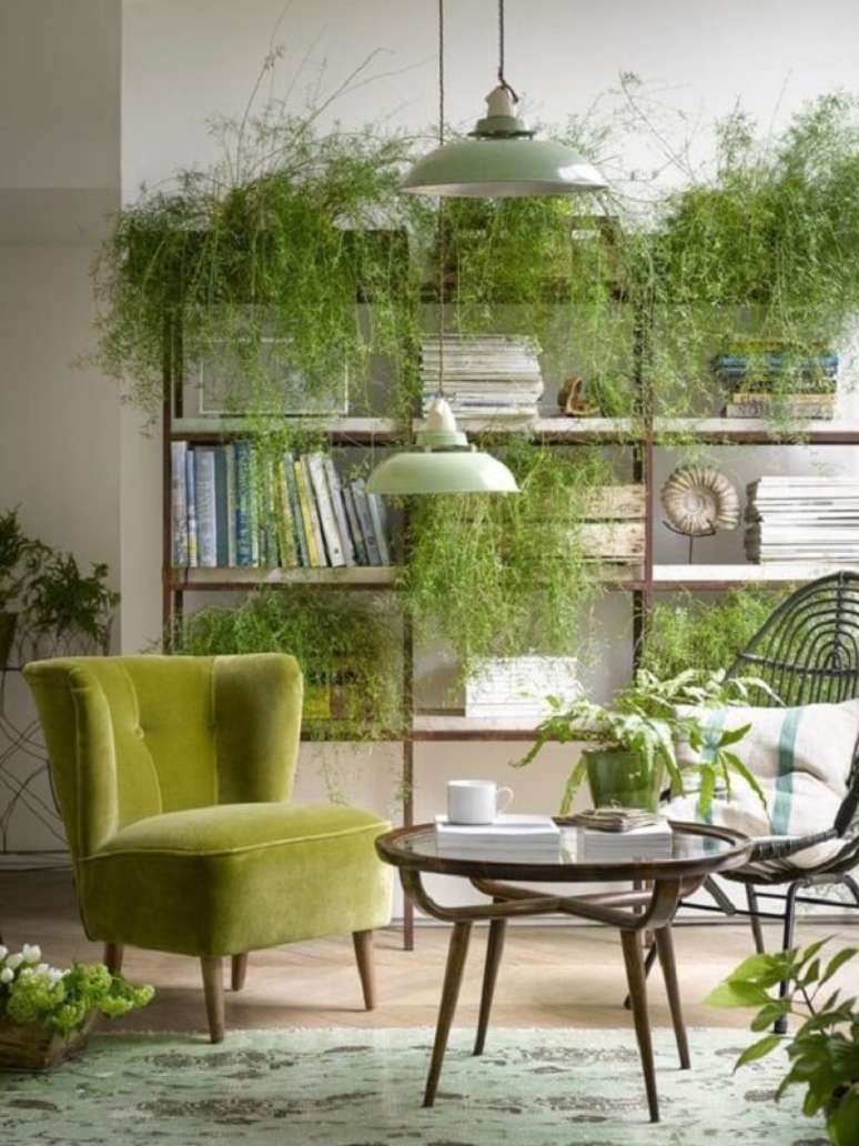 41. A poltrona pé palito verde se mistura em meio as plantas da sala de estar. Fonte: Pinterest