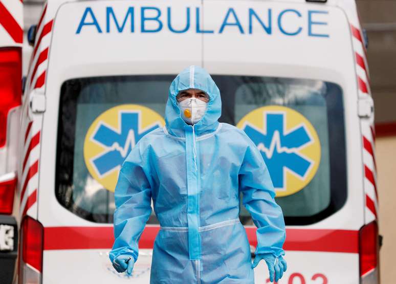 Profissional de saúde com trajes de proteção em frente a ambulância do lado de fora de hospital em Kiev, na Ucrânia
24/11/2020 REUTERS/Gleb Garanich