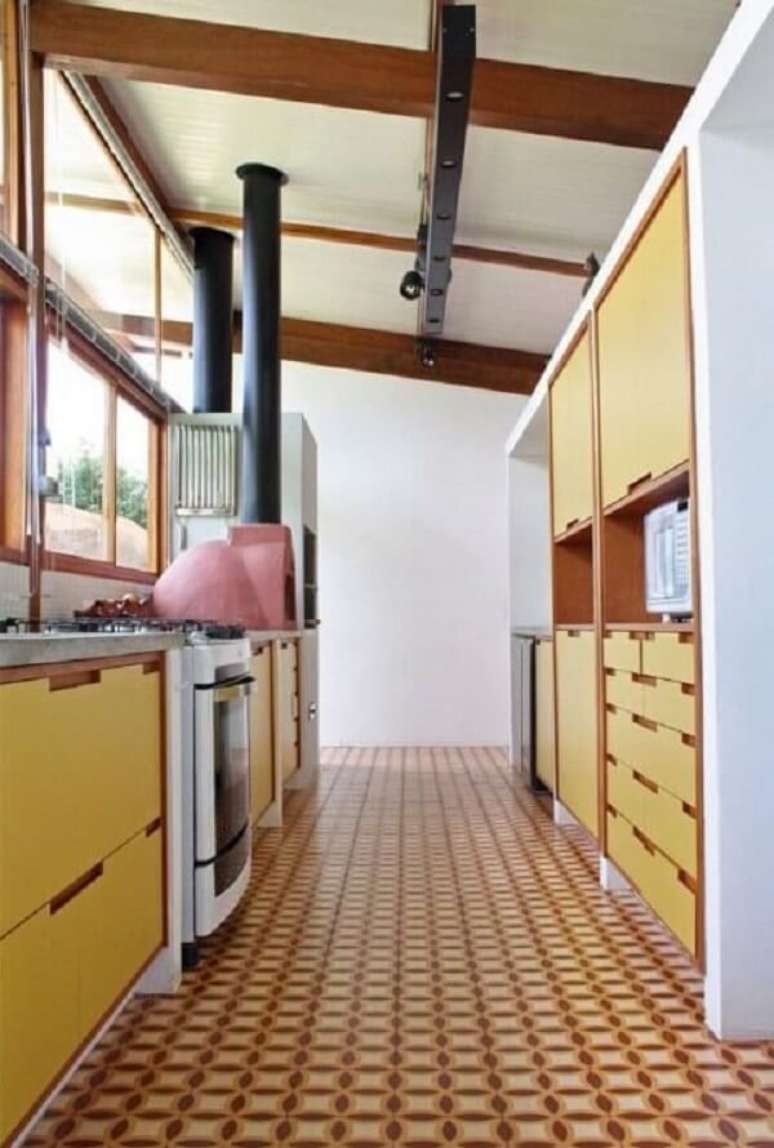48. Cozinha com armários amarelos e piso coloridos em tons terrosos. Fonte: Zehbra Arquitetura