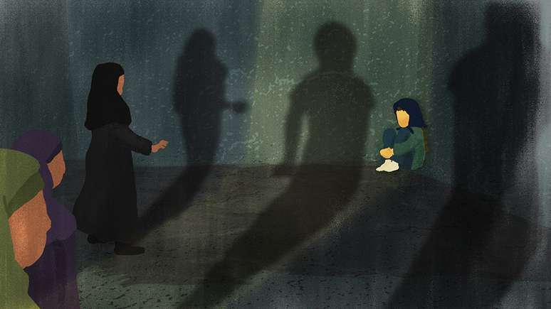 Three women approach a frightened girl, who is sitting in a ball in the corner of a dark room. Their shadows appear menacing.
