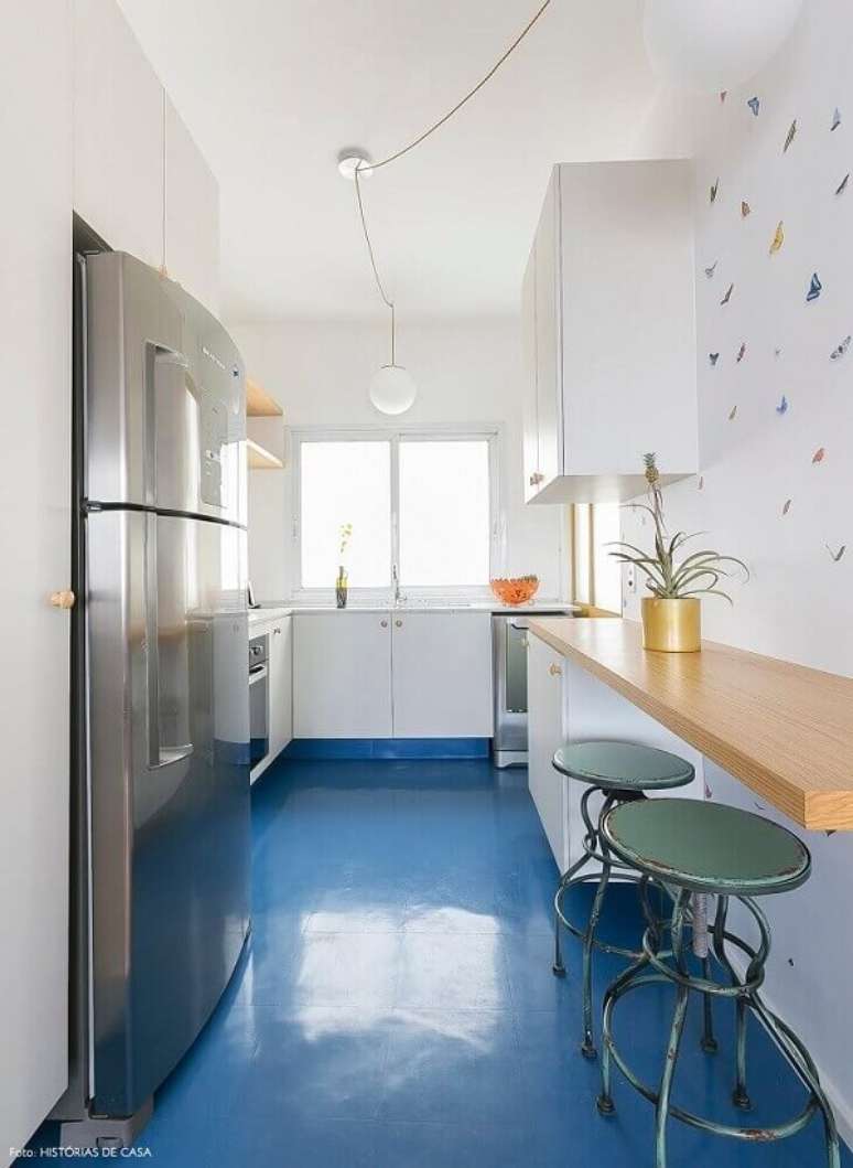 26. Piso colorido cozinha azul, armários brancos e bancada de madeira formam uma linda composição. Fonte: Histórias de Casa