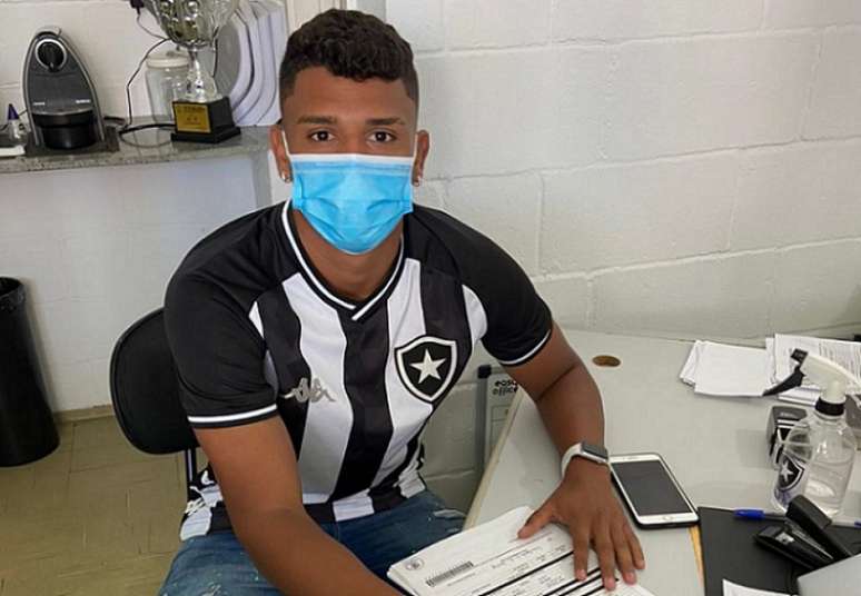 Lucas Goiano assinando contrato pelo Botafogo (Foto: Divulgação)