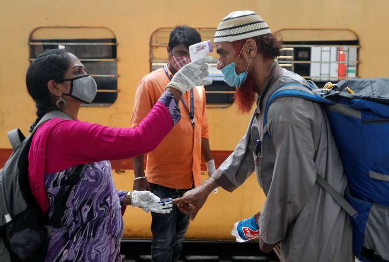 Profissional de saúde checa temperatura e pulso de passageiro em estação ferroviária de Mumbai, na Índia
07/04/2021 REUTERS/Francis Mascarenhas