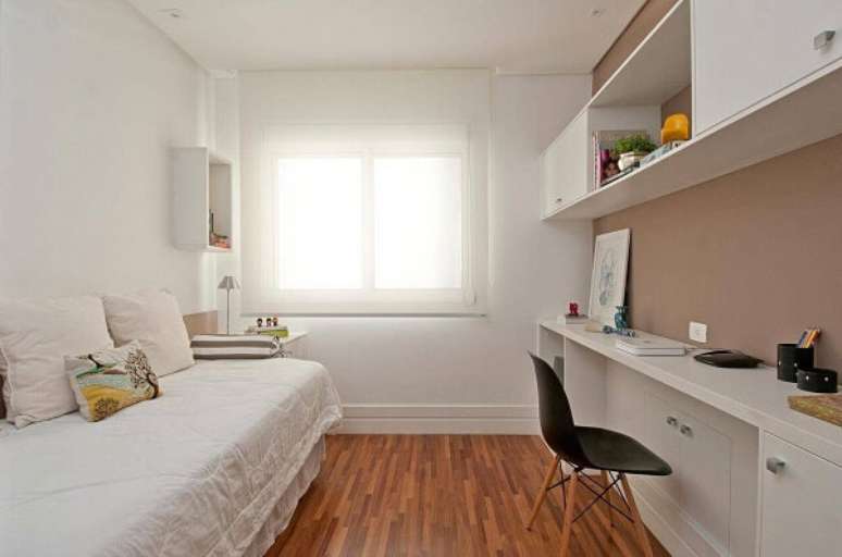 44. Marcenaria branca e piso de madeira colorido decoram o quarto de solteiro. Projeto por Patricia Kolanian
