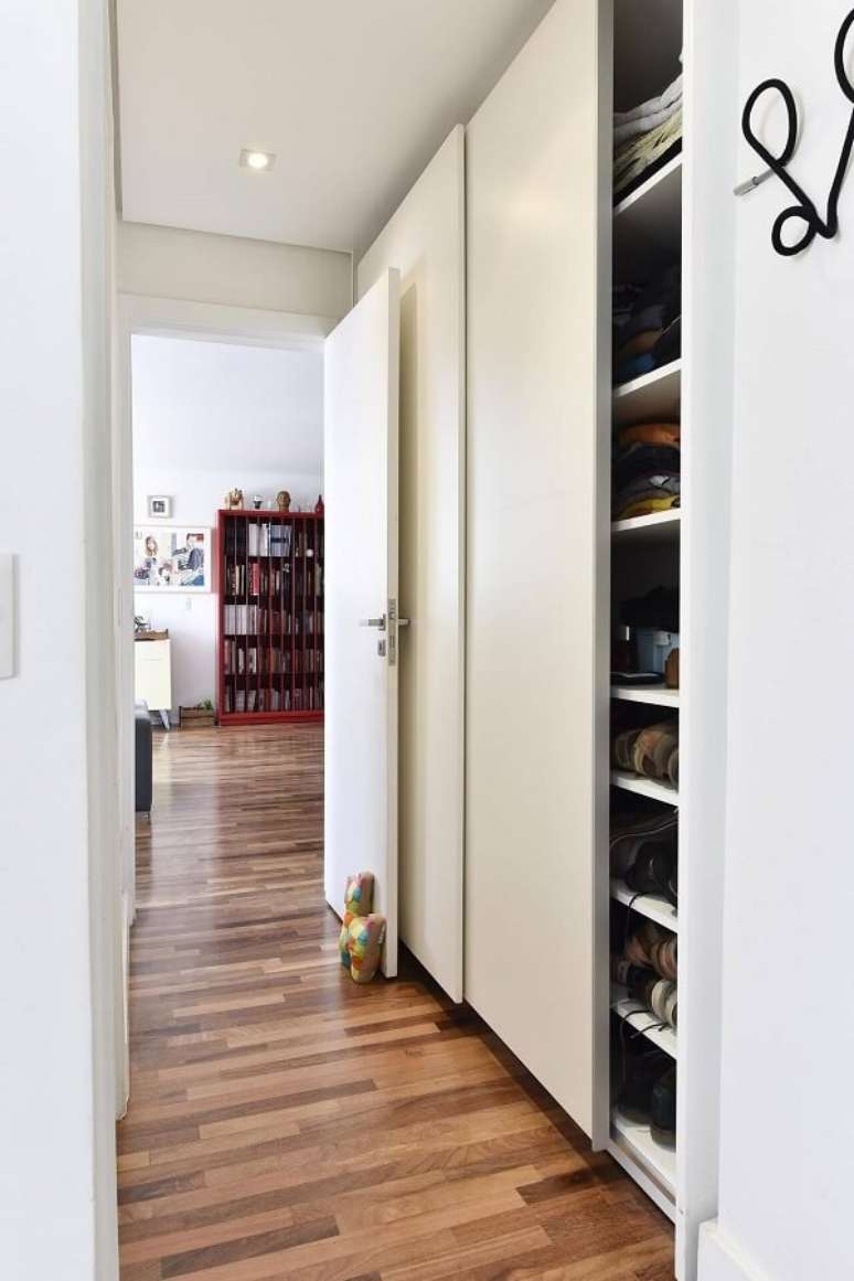 24. O piso de madeira colorido com nuances de marrom se estende por vários cômodos da casa. Projeto por Carla Cuono