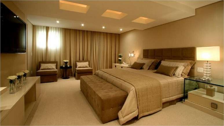 46. Decora&ccedil;&atilde;o de quarto de casal bege amplo com poltronas sem bra&ccedil;o e criado mudo de vidro &ndash; Foto: Decor Salteado