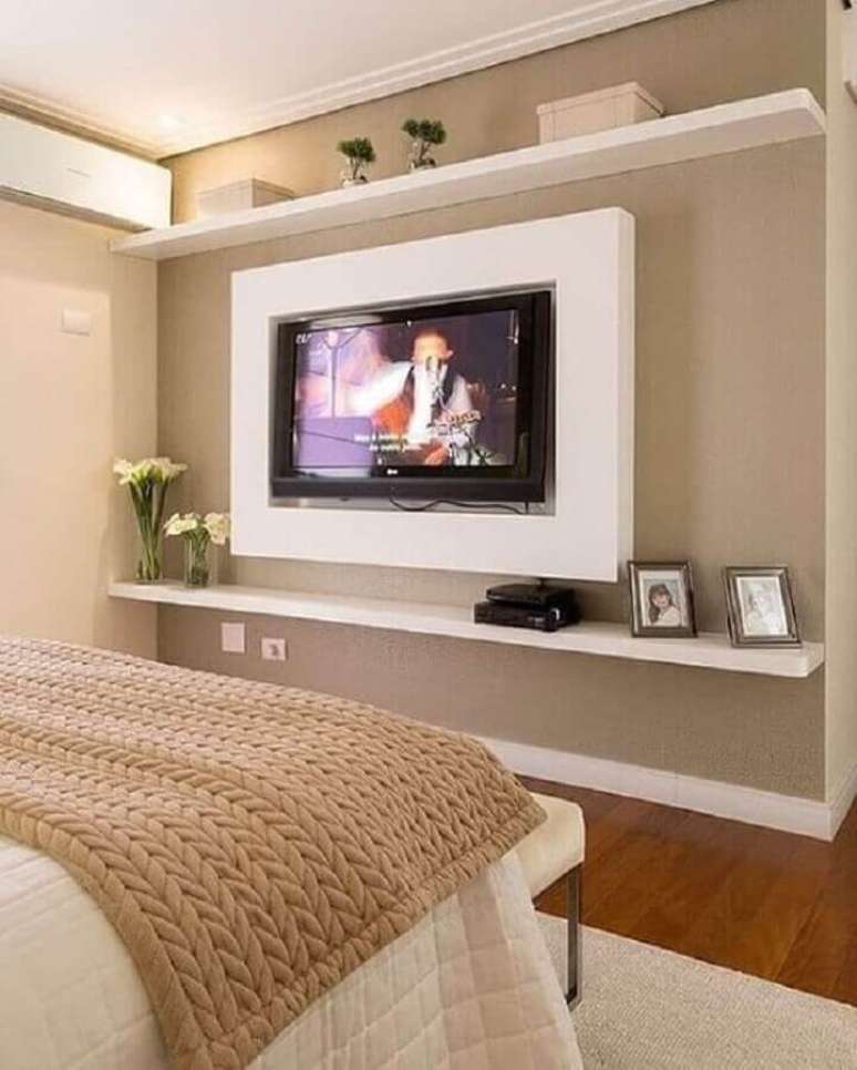 38. Cor bege para quarto de casal decorado com painel de TV – Foto: Pinterest