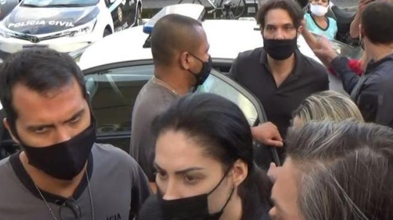 Dr Jairinho (saindo do carro) e Monique (à frente na foto), presos nesta quinta, estão sendo acusados de atrapalhar as investigações sobre a morte do filho dela