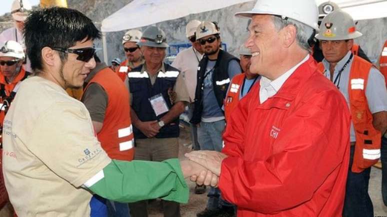 Mineiro &eacute; cumprimentado pelo presidente Pi&ntilde;era, que recebia os resgatados na superf&iacute;cie