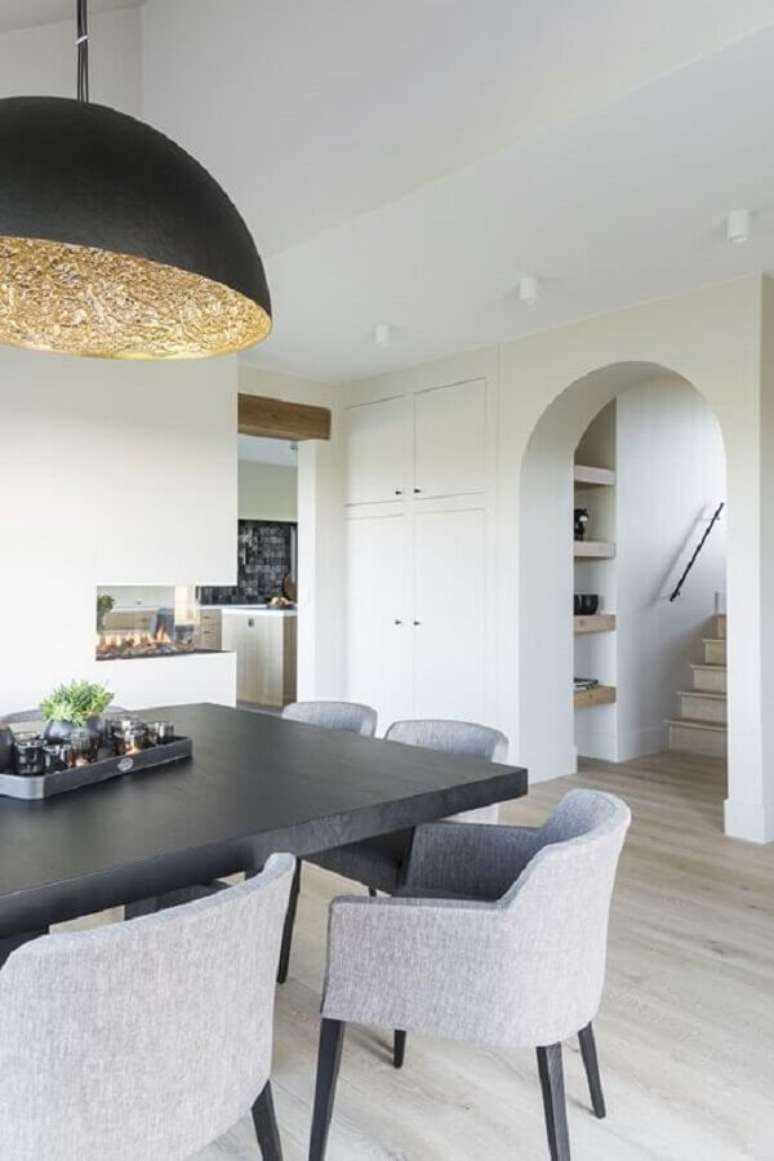 7. Cadeira cinza claro para sala de jantar decorada com lumin&aacute;ria preta redonda &ndash; Foto: Jeito de Casa