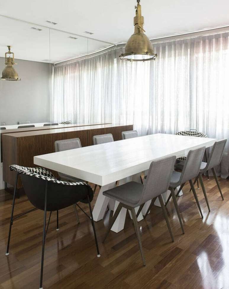 58. Cadeira cinza para mesa de jantar em sala decorada com luminária antiga e parede espelhada – Foto: Pinterest