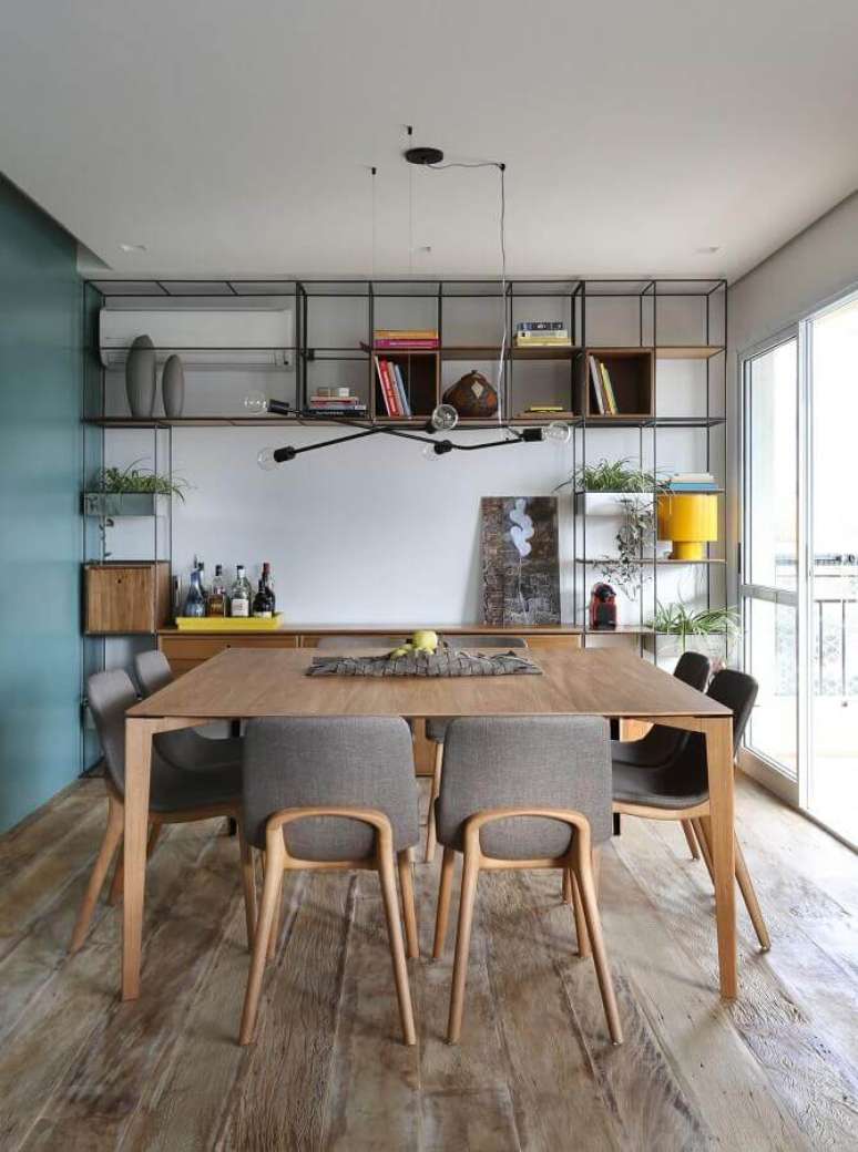 52. Cadeira cinza para mesa de jantar em sala decorada com estante estilo industrial – Foto: Futurist Architecture