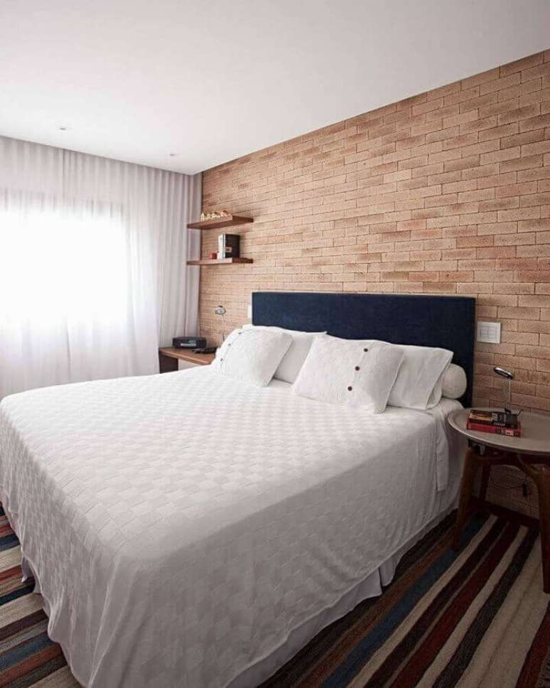 41. Modelos de tapetes listrados para quarto de casal decorado com parede de tijolinho – Foto: Korman Arquitetos