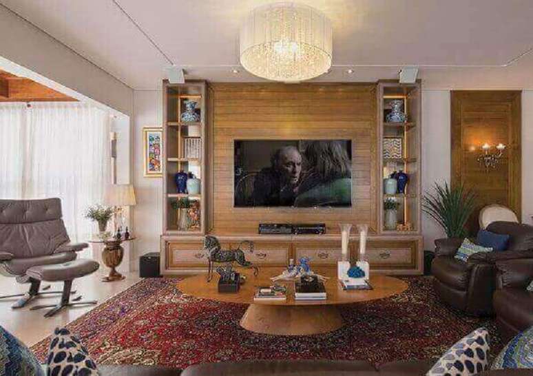 45. Modelo de tapete persa para decoração de sala de TV com poltronas de couro e mesa de centro redonda – Foto: Revista Sua Casa